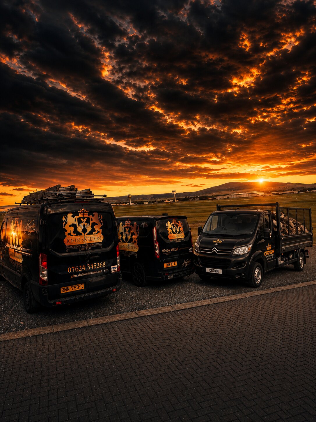 The Crown Painters and Crown Removals branded fleet at sunset on the Isle of Man